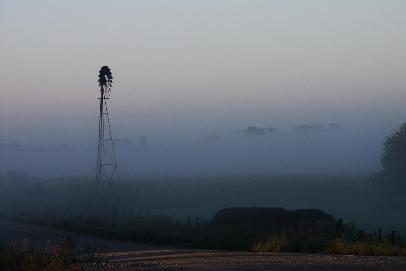 Windmill shrouded in fog at a farm outside of Walker, Iowa